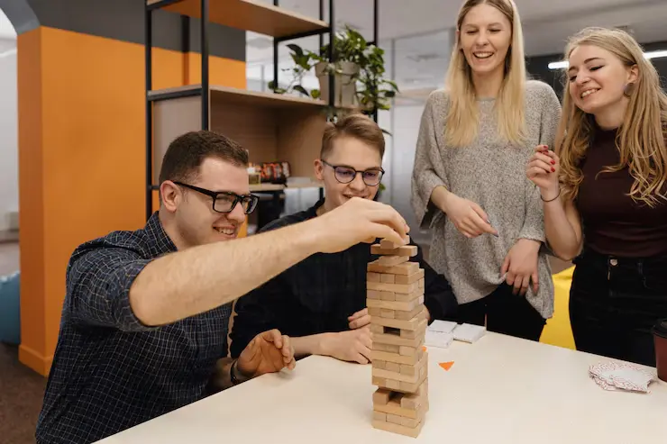 Unity Game Development Agency in Canada Team playing a wooden blocks game in a collaborative office environment.