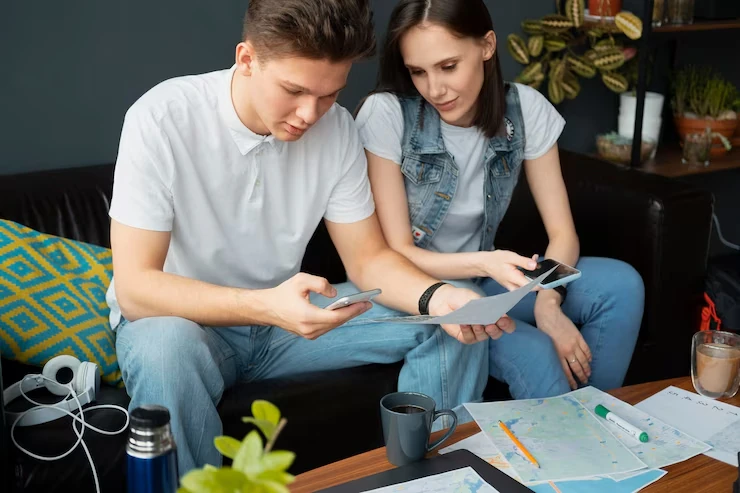 Game testing and quality assurance in Canada with a boy and girl reviewing papers and playing games on mobile at a table